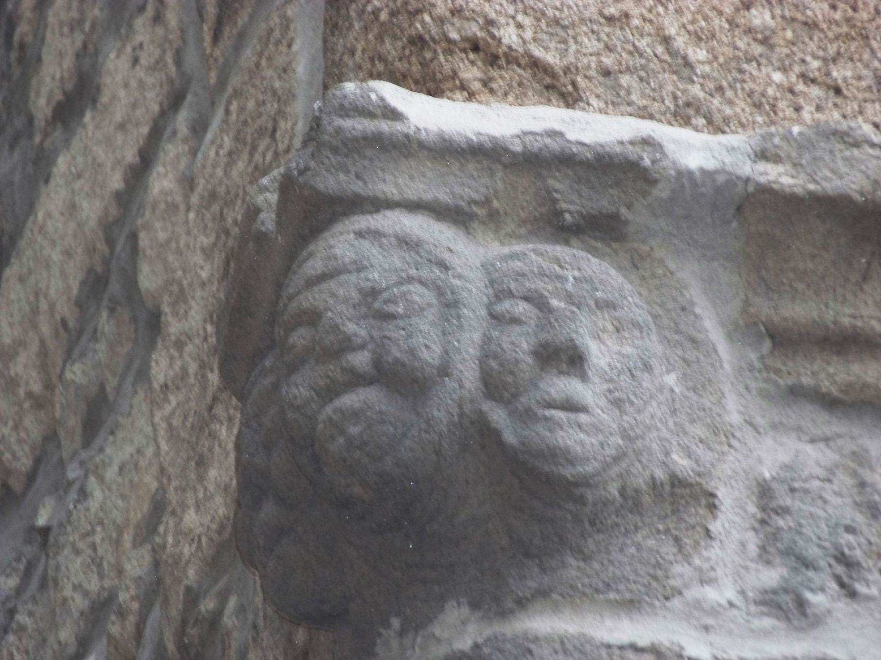 sculpture de 3 têtes de poupons dans la pierre